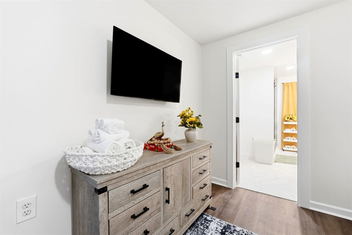 Finally, the basement bedroom features a beautiful, cool-toned color scheme with natural accents, a king bed, and a Roku-powered Smart TV. This room includes 2 full-body towels, 2 washcloths, and 2 hand towels for your stay.