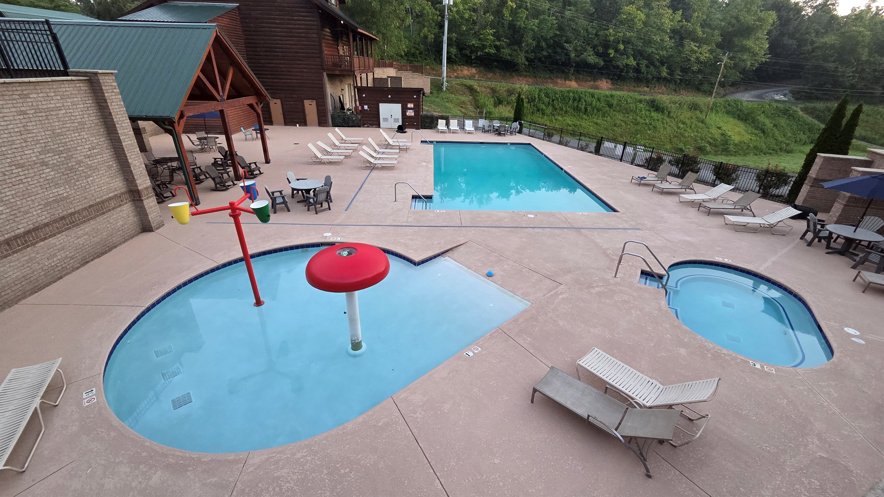 Family-friendly resort pool area featuring a splash zone, large swimming pool, and relaxing hot tub