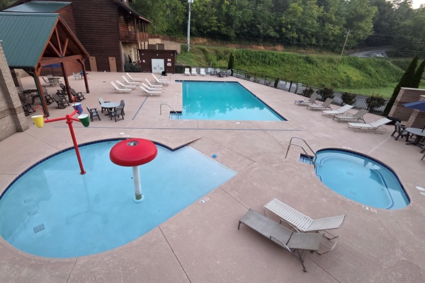 Family-friendly resort pool area featuring a splash zone, large swimming pool, and relaxing hot tub