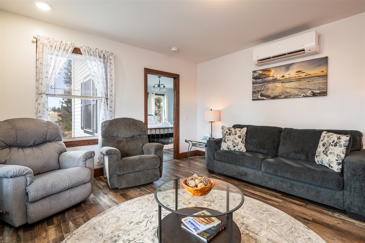 Relax in this cozy living room featuring plush seating, natural light, and Finger Lakes charm.