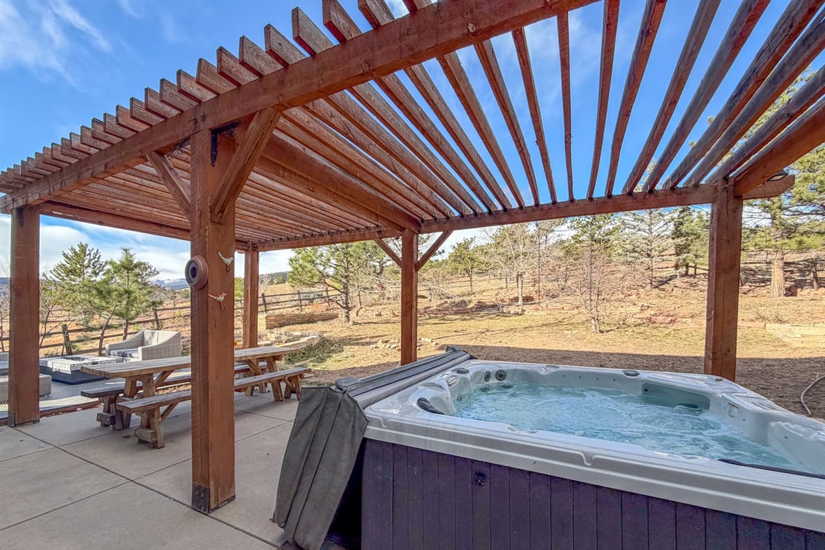 Our 6 person, cozy hot tub sits beneath a stylish wooden pergola, creating a private and inviting outdoor retreat