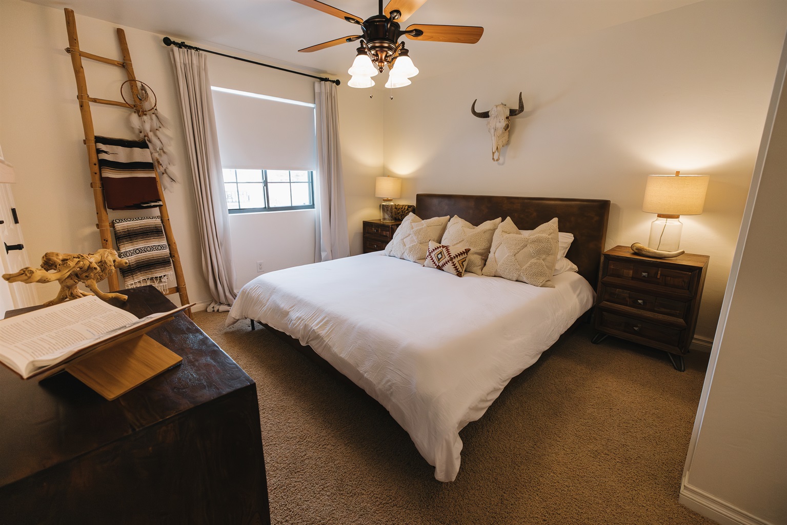 Spacious primary bedroom with a plush king bed, warm wood accents, and cozy mountain décor. A peaceful retreat for couples and families visiting Pinetop, close to lakes, hiking, and Sunrise Ski Resort.
