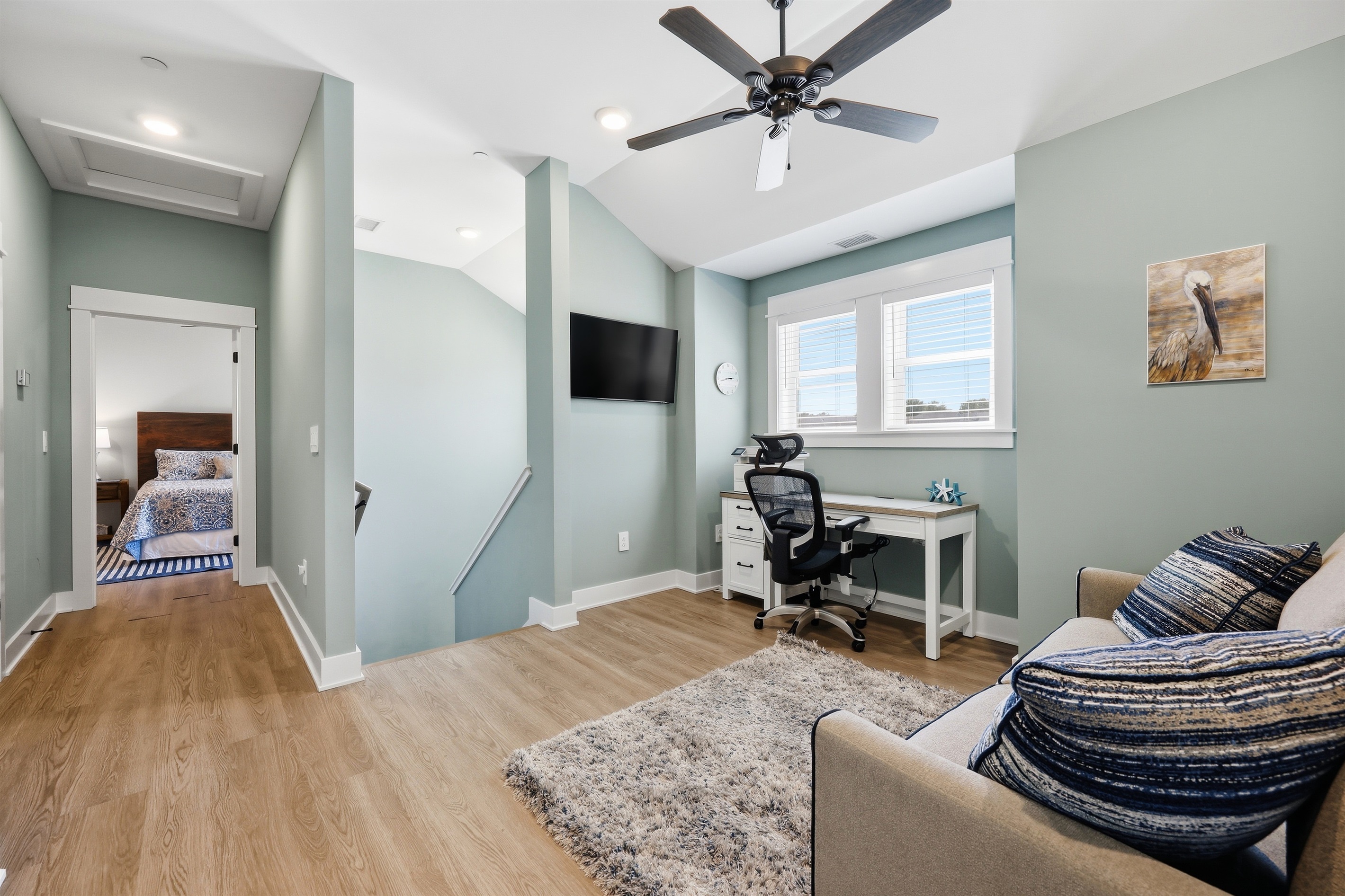 Flexible loft space featuring a workspace, sitting area, and sleeper sofa.
