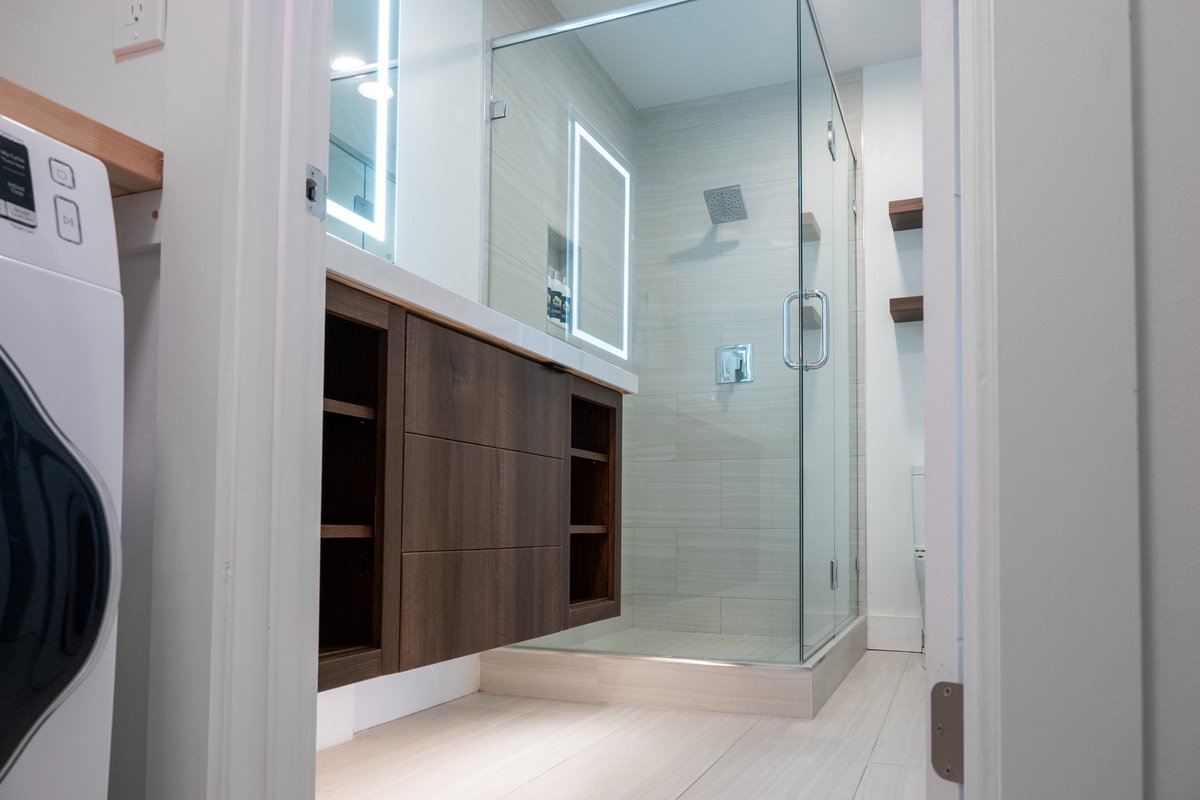 Primary bathroom featuring a glass-enclosed shower, oversized vanity, and plenty of storage.