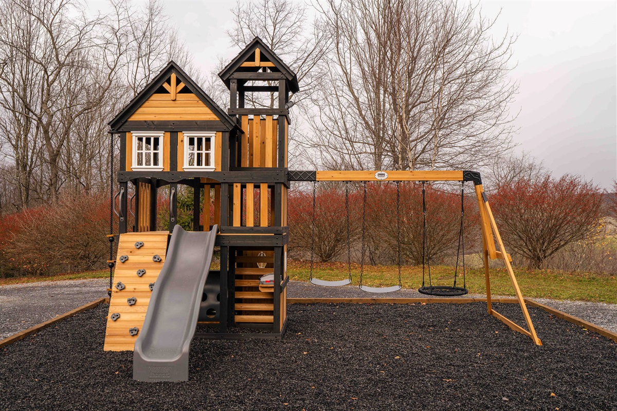 Kids’ swingset and play tower with slide, swings, and climbing wall
