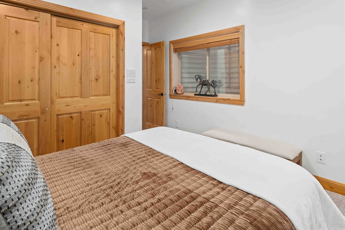 Bedroom with warm wood finishes and convenient storage.