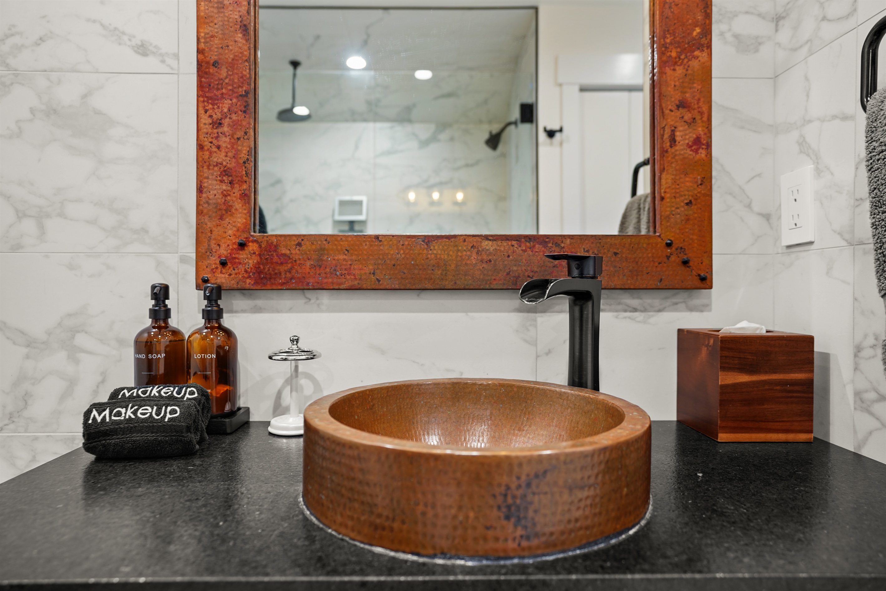 Bathroom with standing shower, toiletries, and bath linens provided
