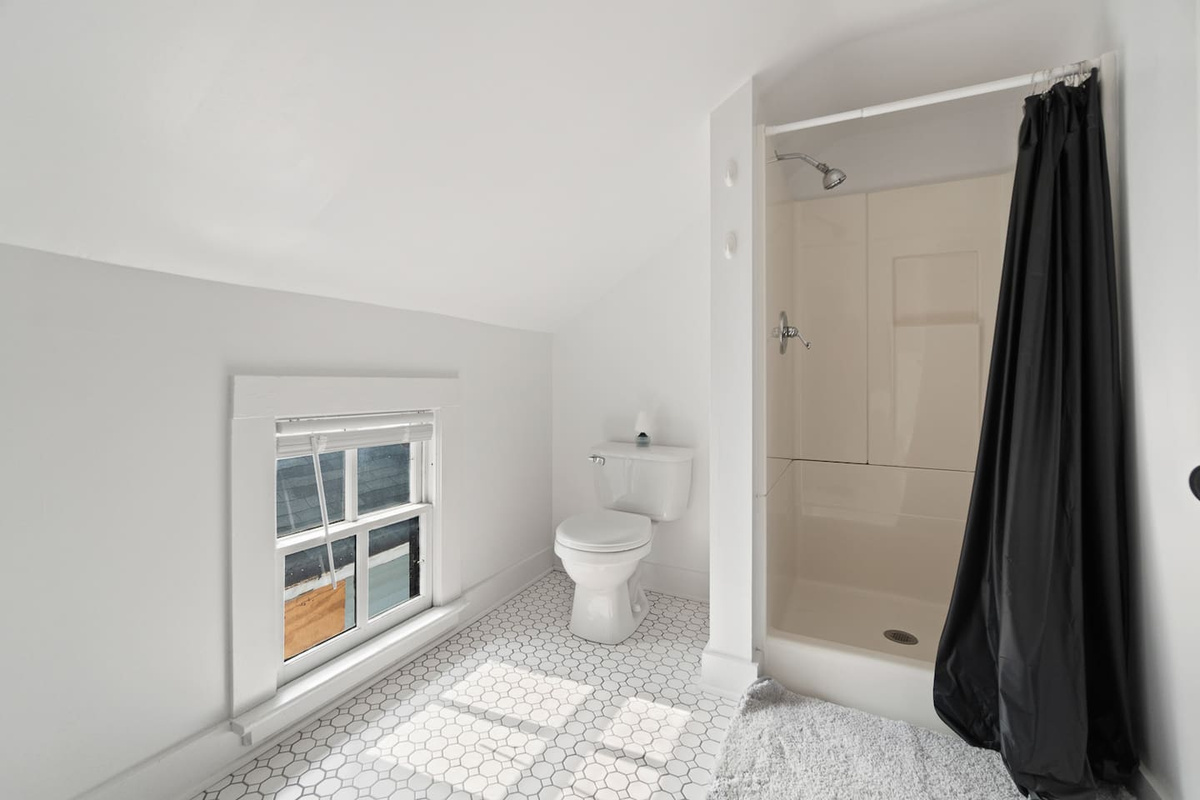 Modern bathroom featuring a spacious shower and a window that fills the space with natural light, creating a refreshing and inviting atmosphere.