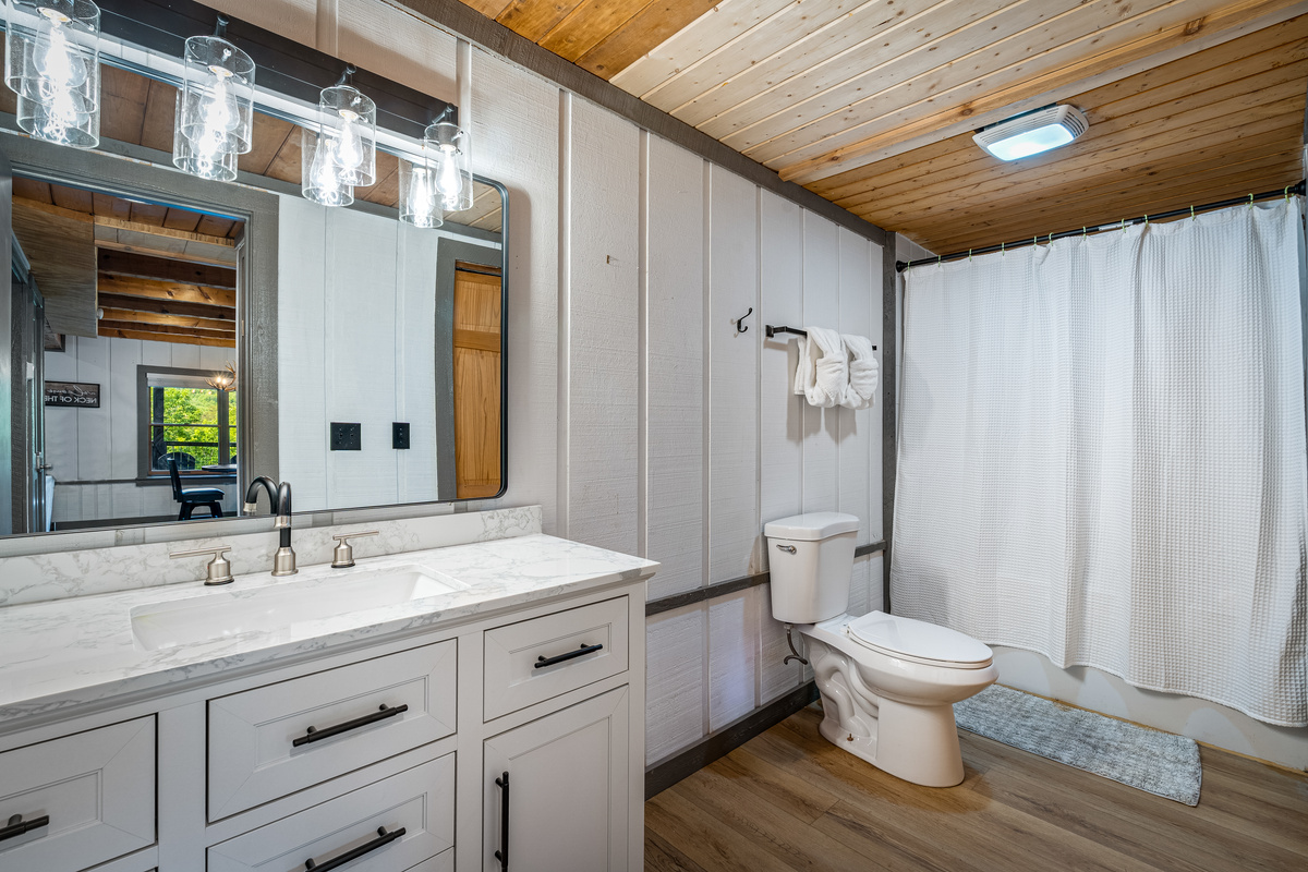 Lower level bathroom, adjacent to the bedroom. Features bath and shower.