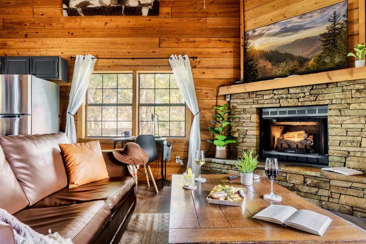 Charming living room with a fireplace and couches, perfect for chilling in a Sevierville cabin rental. 