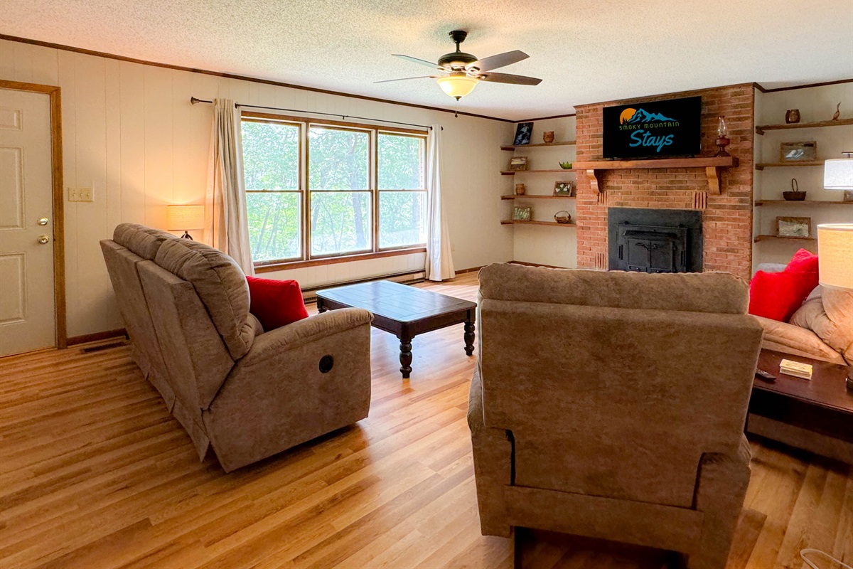 The living room is spacious and comfortable! The living room features a 48" Smart TV, reclining chairs, and a slight view of the mountains. Cherry on top! Please note the old wood stove is not a listed amenity and not available for usage at this time.
