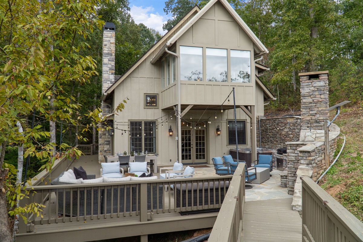 Relax outdoors with dining space, a soothing hot tub, and comfortable seating around the fireplace—perfect for evening meals, quiet soaks, and cozy nights under the stars.