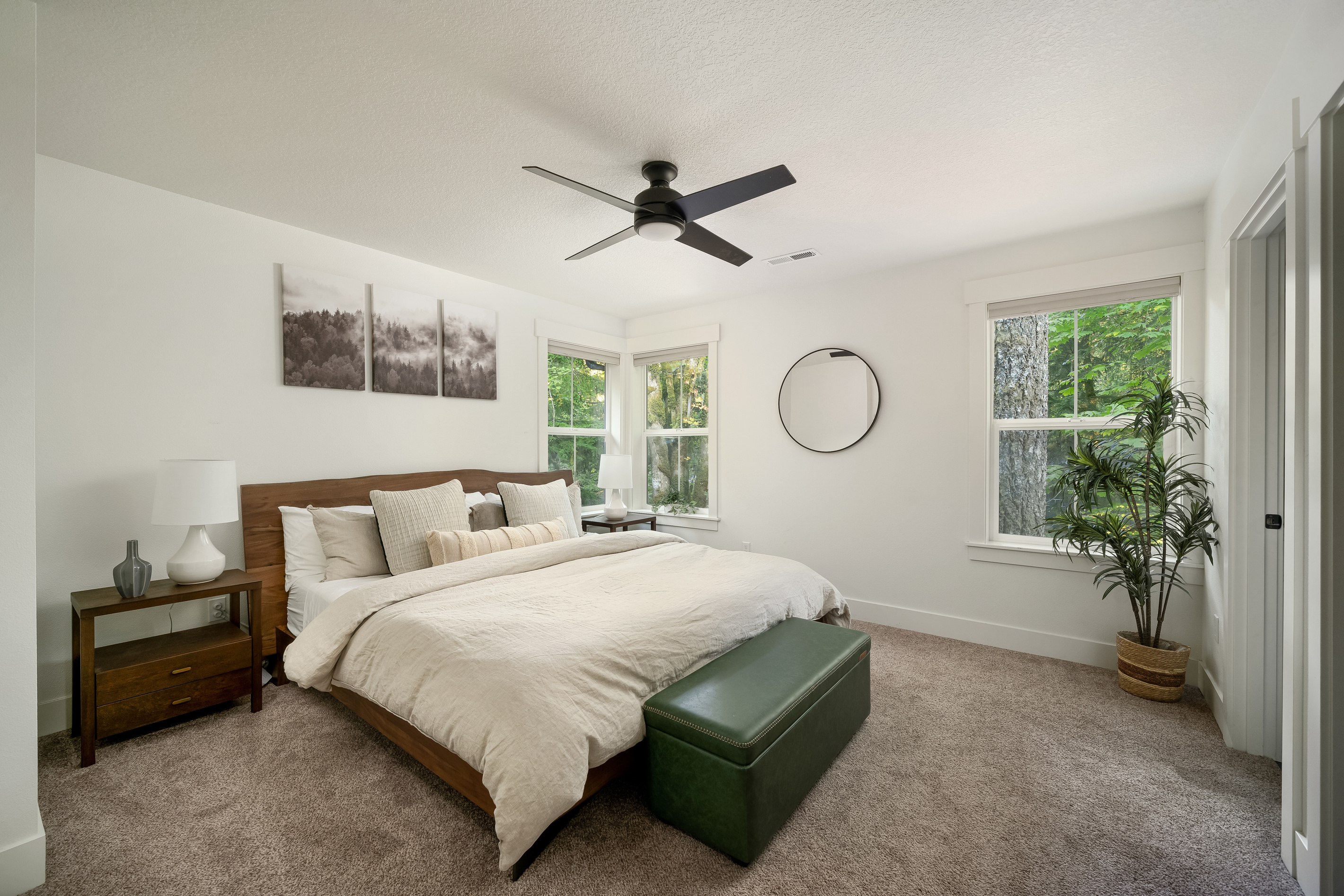 A serene primary king bed retreat with treetop views on two sides.
