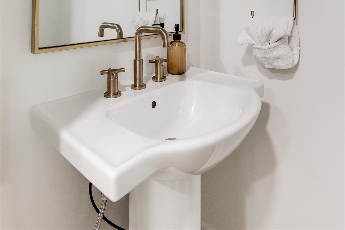 Stylish Half Bath: Enjoy modern fixtures and elegant lighting in this chic, bright space!