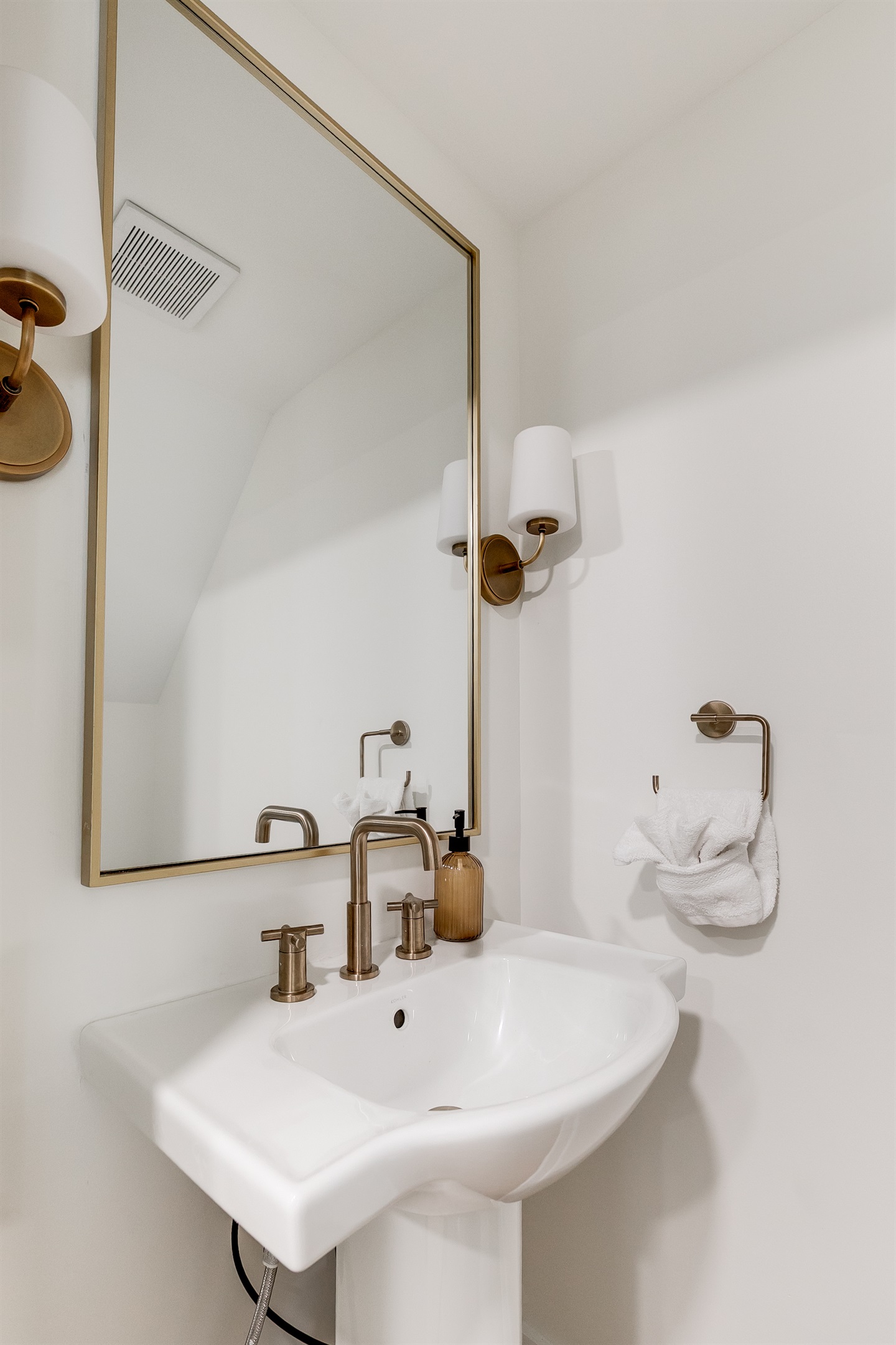 Stylish Half Bath: Enjoy modern fixtures and elegant lighting in this chic, bright space!