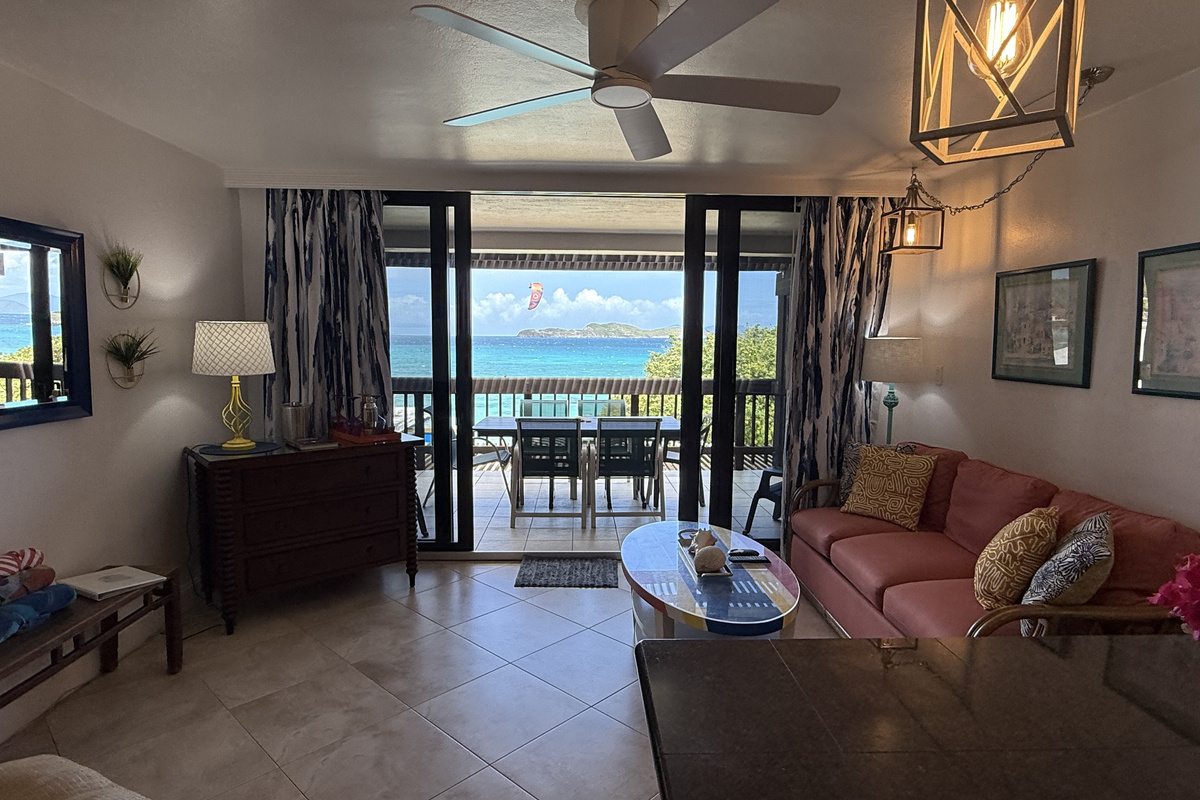 Living room opens to balcony with gorgeous turquoise water steps away