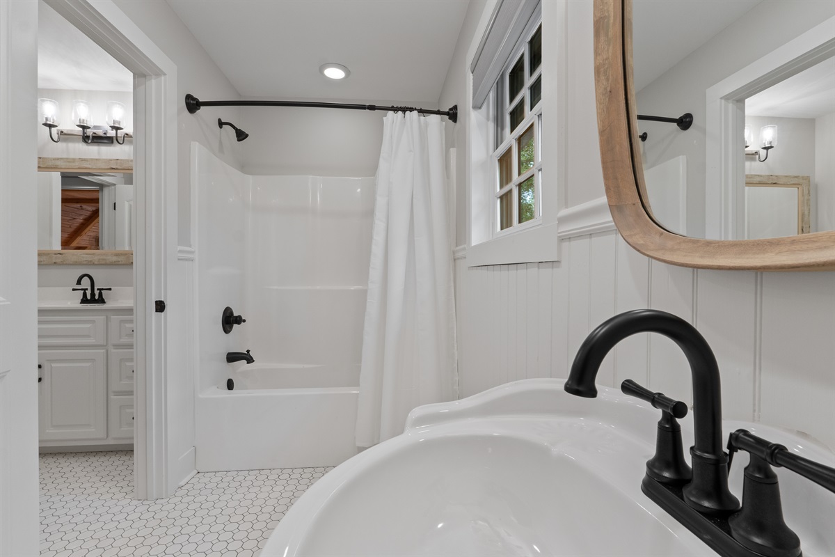 The second bathroom features a shower-tub combination and an additional sink, providing extra space and convenience for guests.