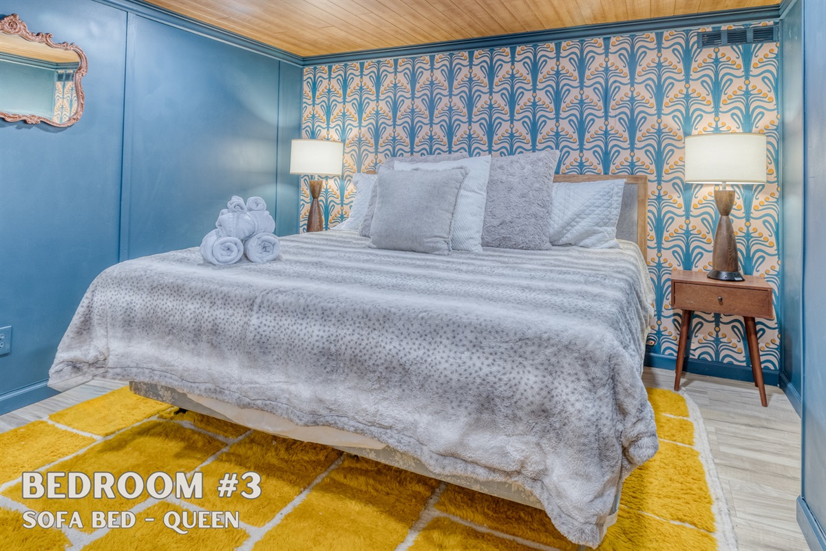 On the bottom floor, Bedroom #3 features a plush queen-sized sofa bed with luxurious linens for ultimate comfort and relaxation.
