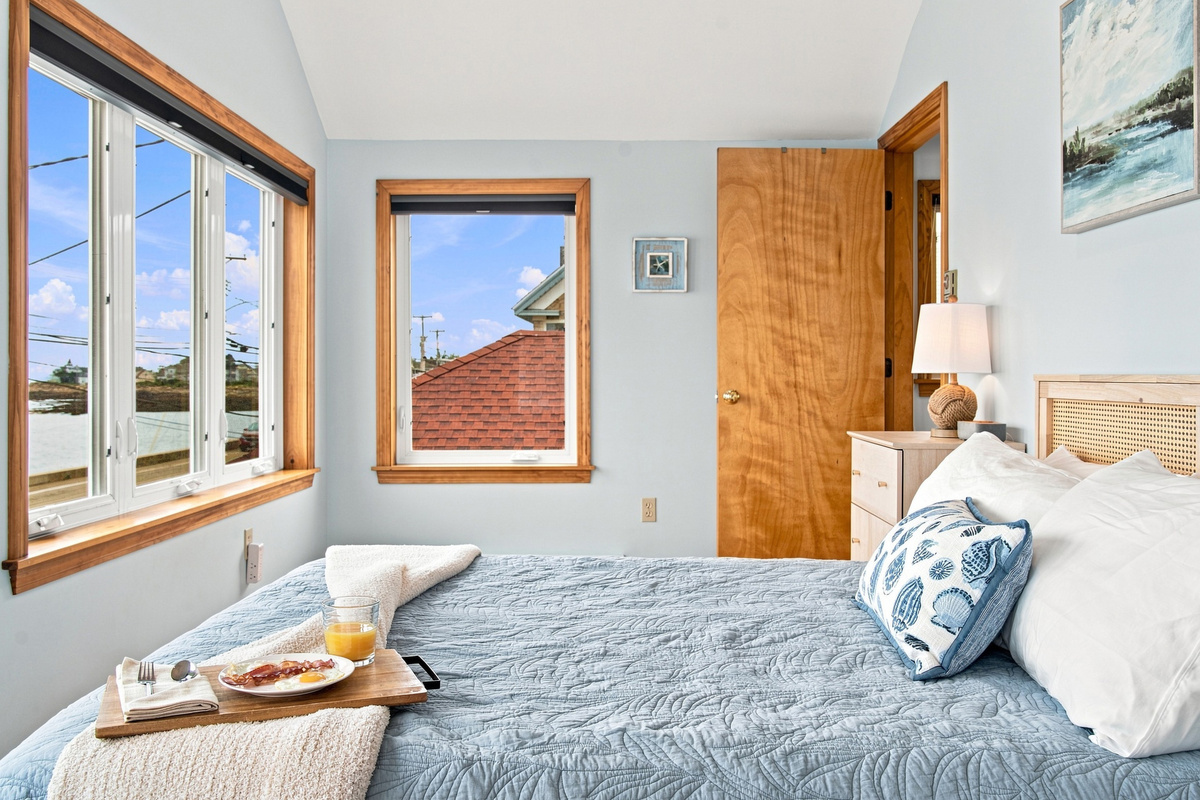 Bright bedroom featuring a queen bed and scenic ocean views.