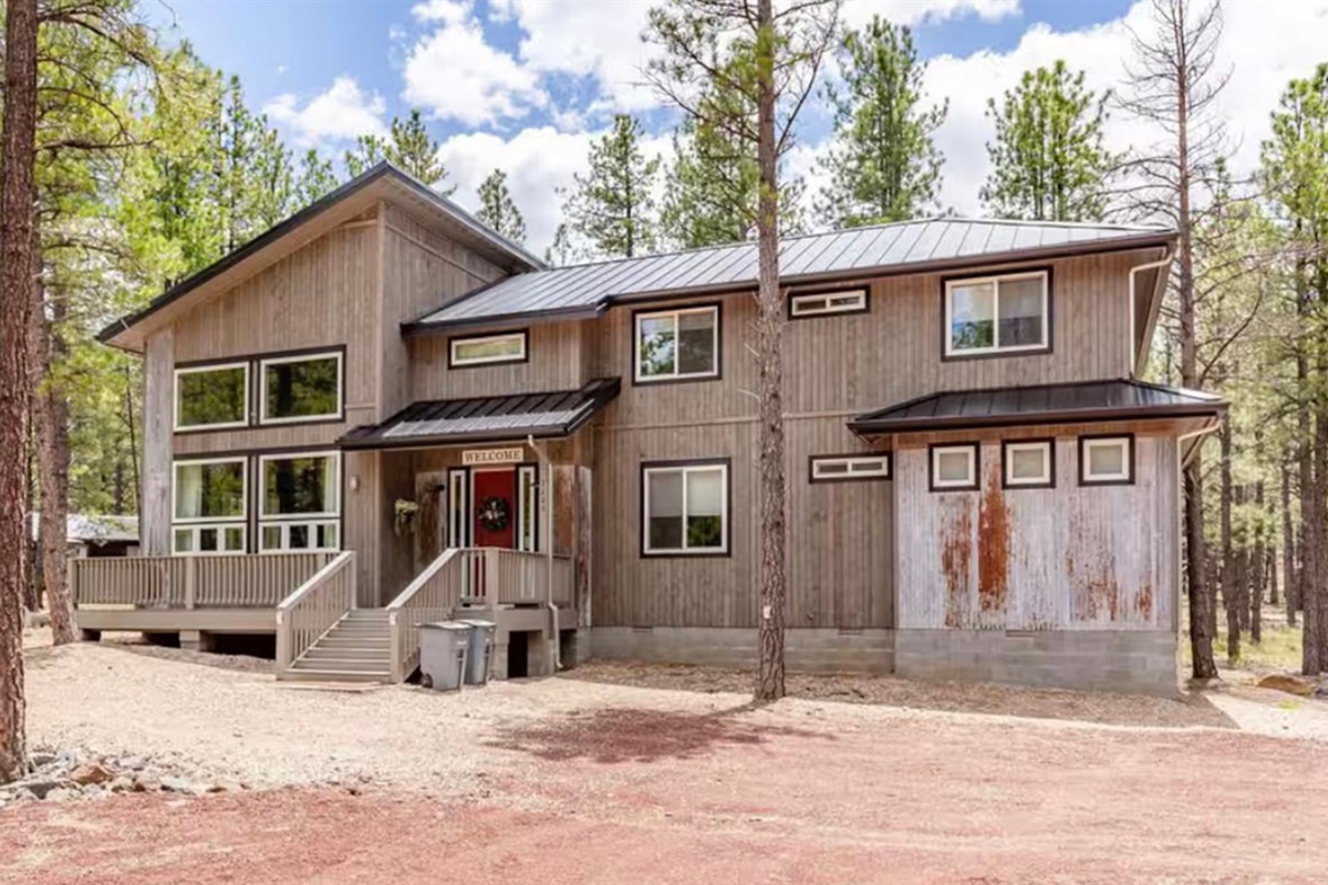 Another view of the spacious cabin exterior and wooded setting.