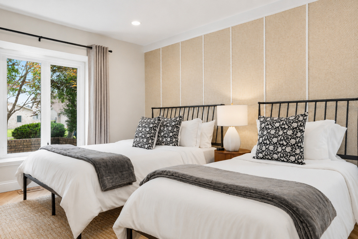 Spacious, sunlit bedroom with plush beds, modern decor, and serene views—perfect for a relaxing stay.