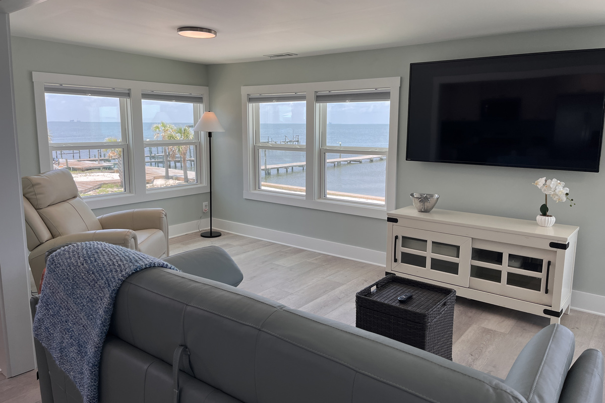 The living room offers an expansive, comfortable space perfect for entertaining, complete with stunning views of the bay.