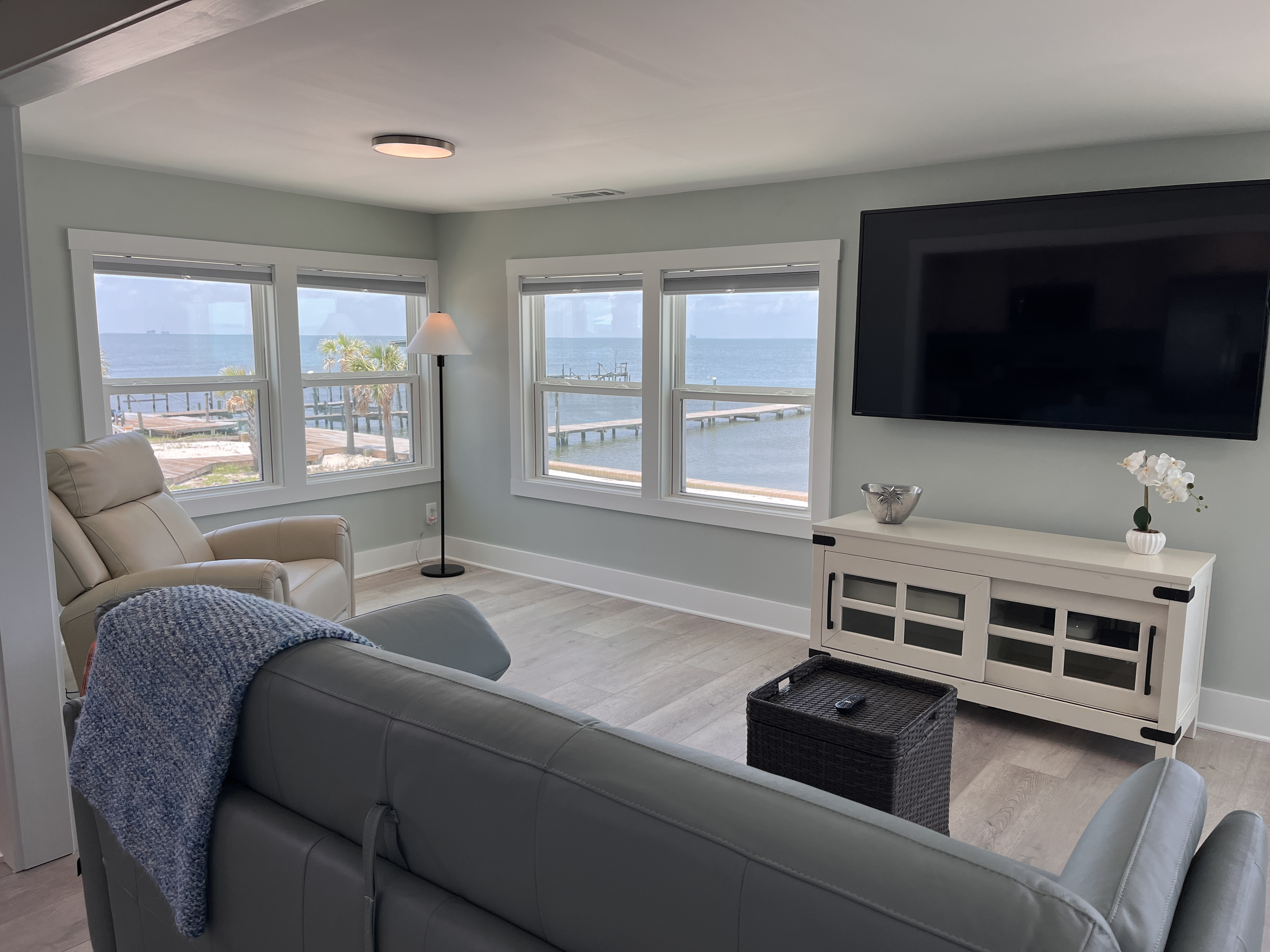 The living room offers an expansive, comfortable space perfect for entertaining, complete with stunning views of the bay.