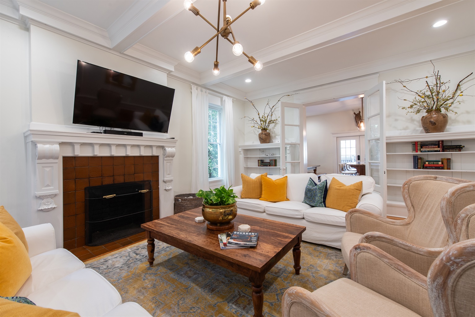 Relax in this stylish living room on the Bourbon Trail in Louisville’s Highlands! Enjoy a modern chandelier, comfy seating and decorative fireplace—perfect for unwinding after distillery tours