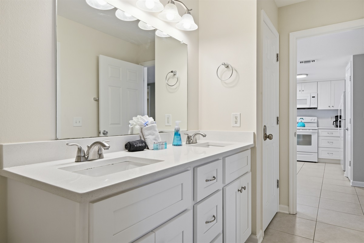 Conveniently located near the kitchen and guest bedroom, this bathroom features modern vanities and plenty of space.