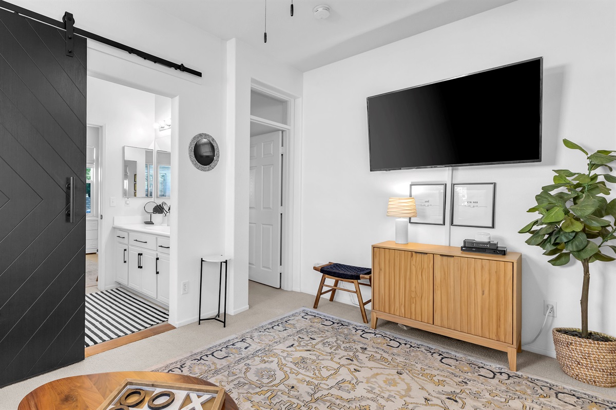 Relax in the stylish bonus room featuring a comfy sofa and TV for your favorite shows or quiet downtime.