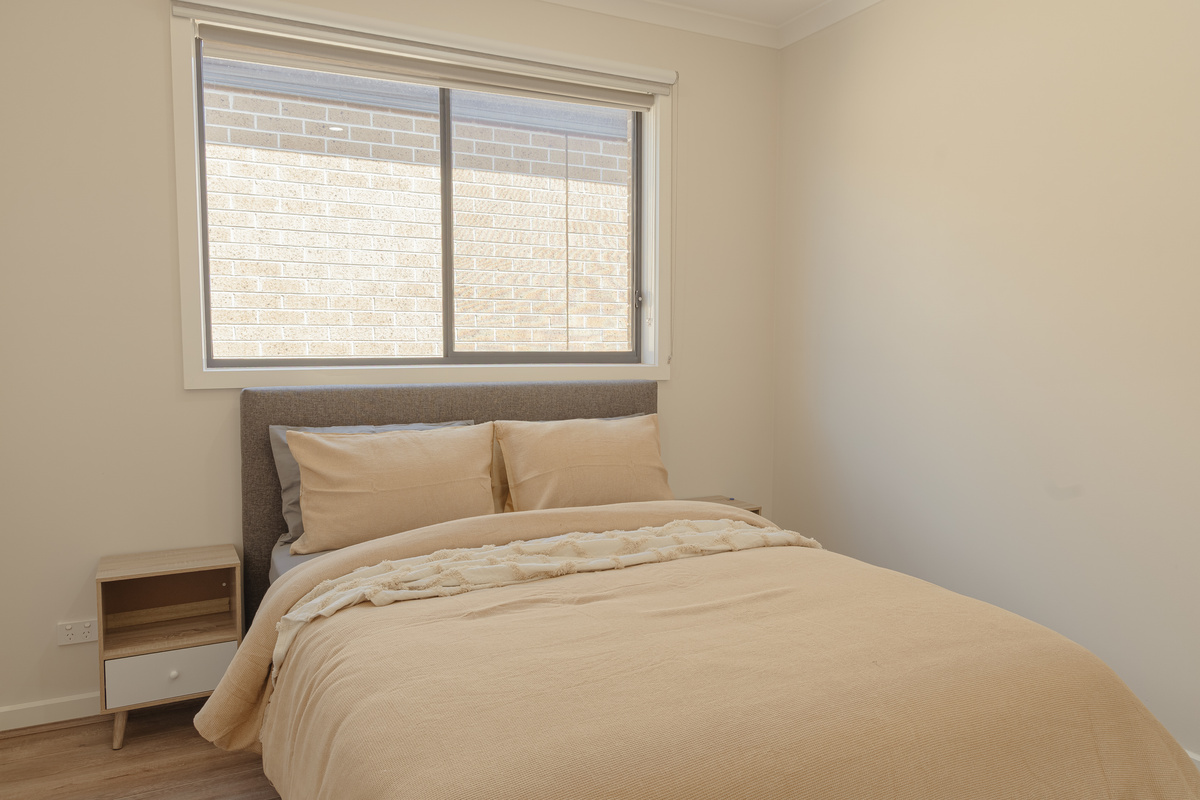 Warm neutral tones and soft layered bedding give this bedroom a calm, easy feel for settling in during the stay.