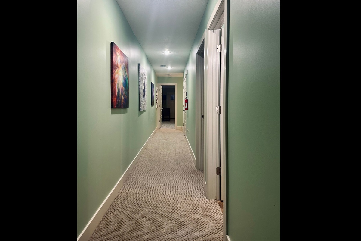 Upper-level hallway facing west toward the private primary suite, offering a calm and organized flow between spaces.