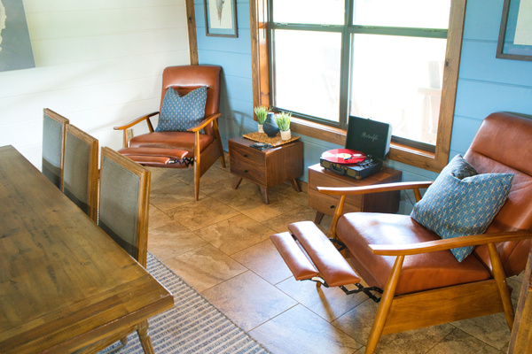 Cozy sitting area with recliners, record player, and board/card games nearby.