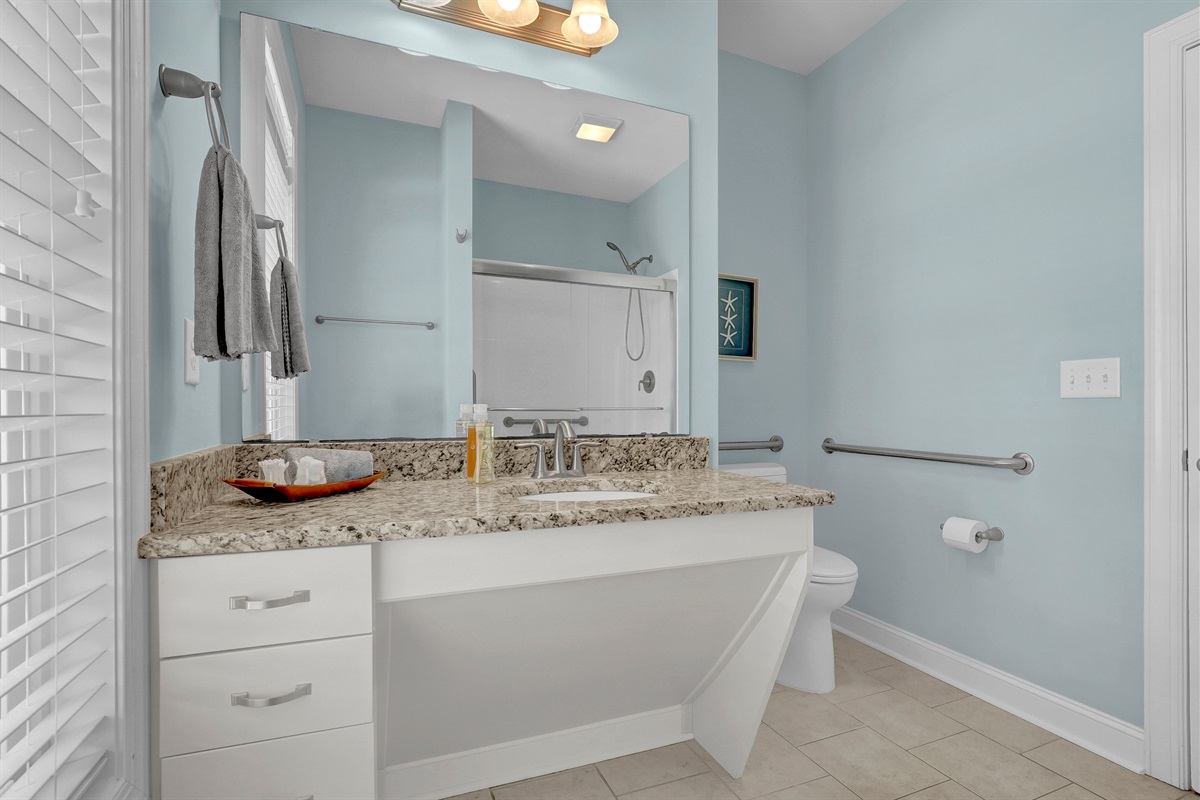 Spacious, accessible-friendly bathroom featuring wide clearances and modern granite.