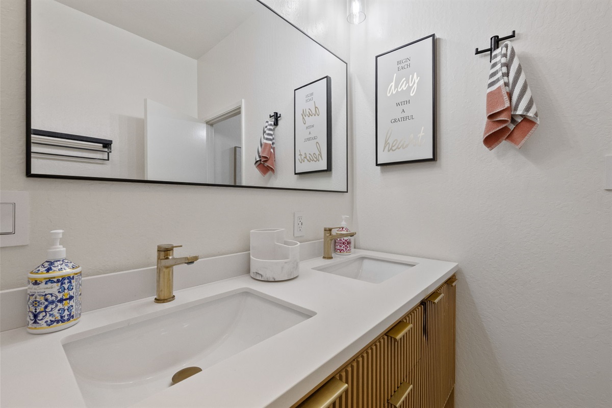 Downstairs bathroom with dual sinks, shower and toilet.