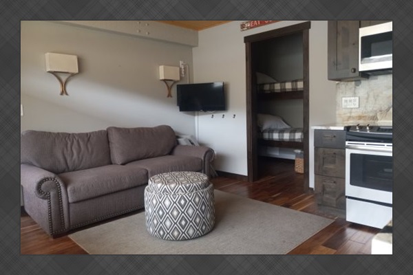 Livingroom area leading to small room with twin bunkbeds & bathroom area. 