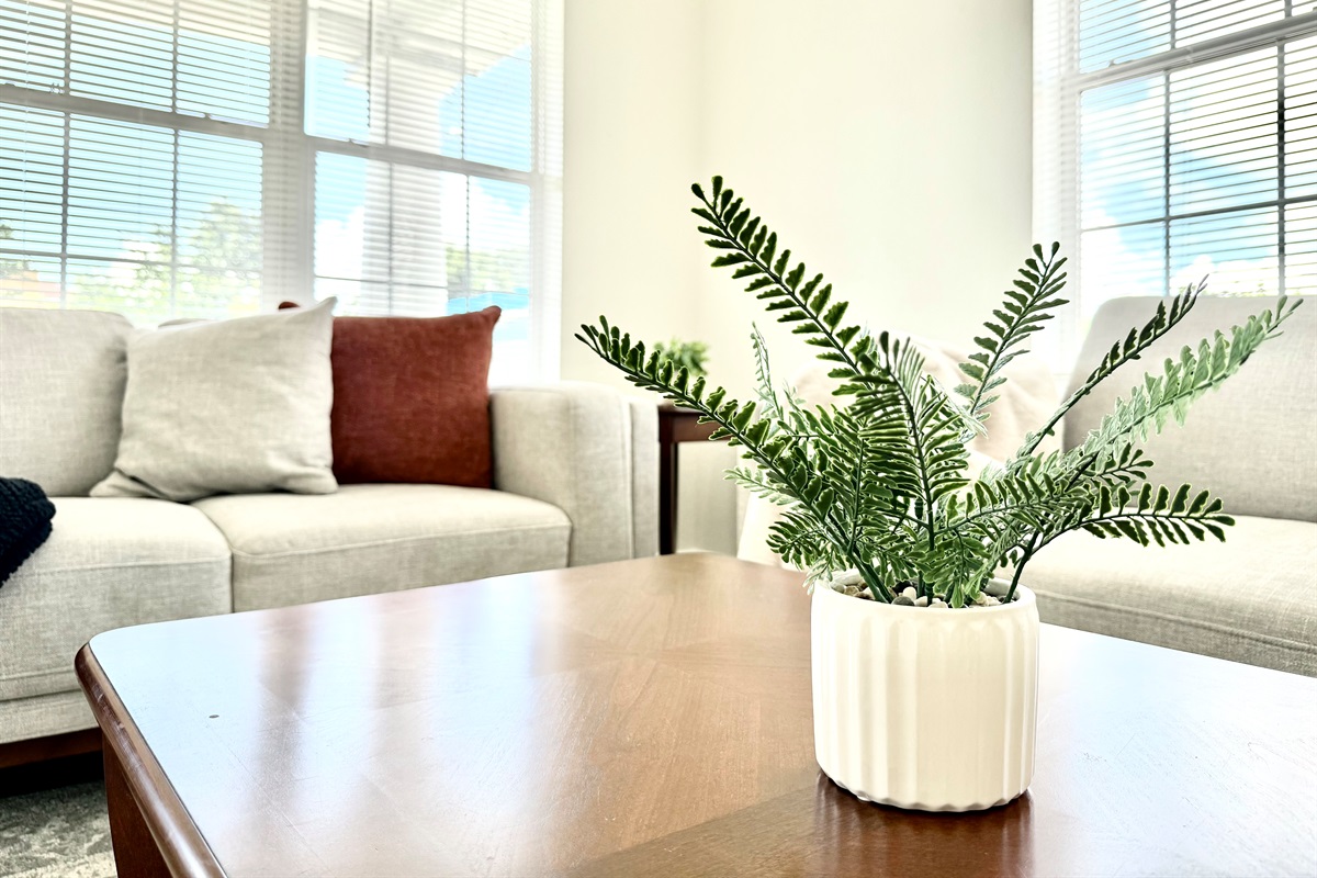 Step into a spacious, light-filled living room featuring high ceilings, neutral tones, and tasteful décor.