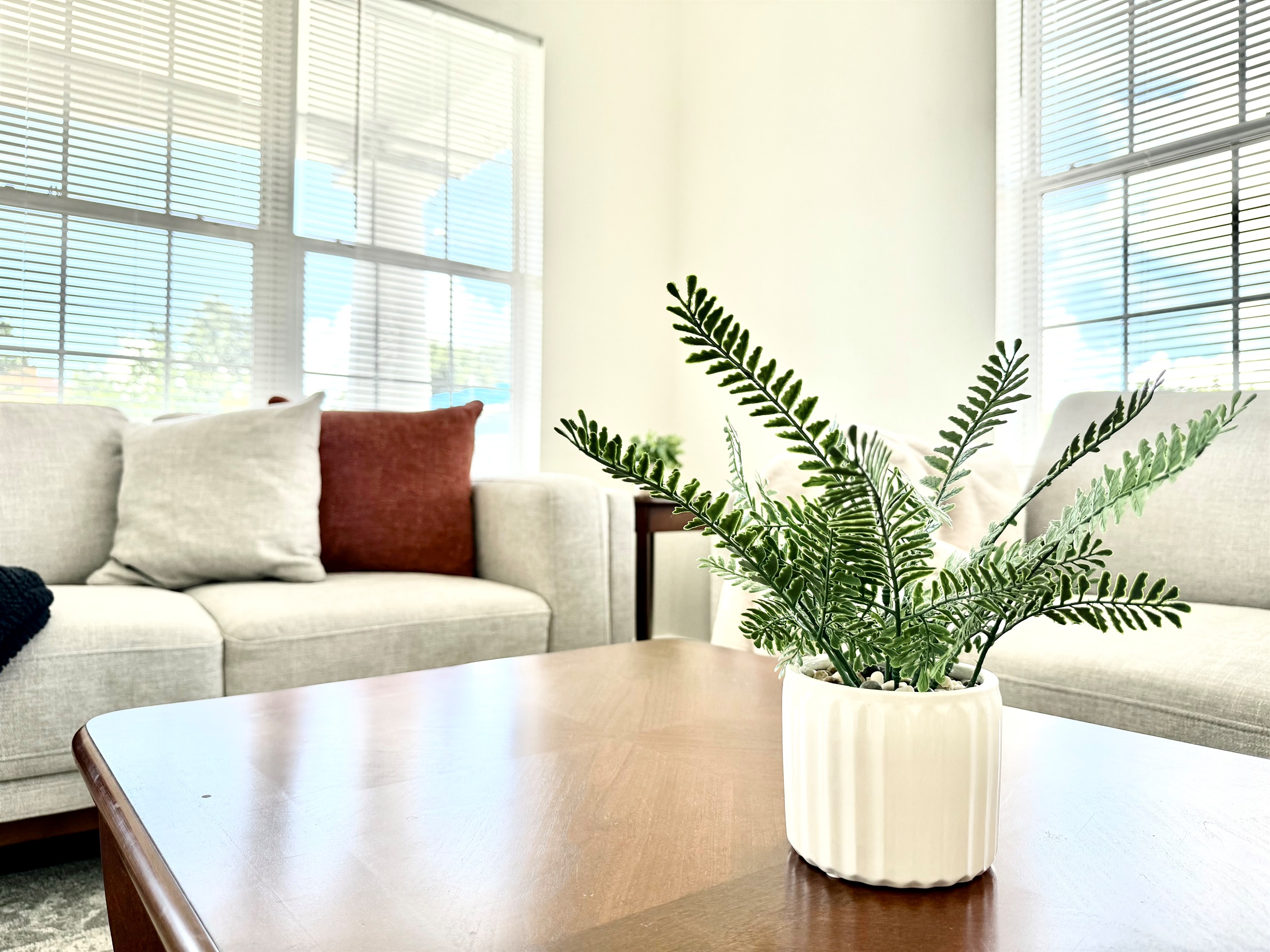 Step into a spacious, light-filled living room featuring high ceilings, neutral tones, and tasteful décor.