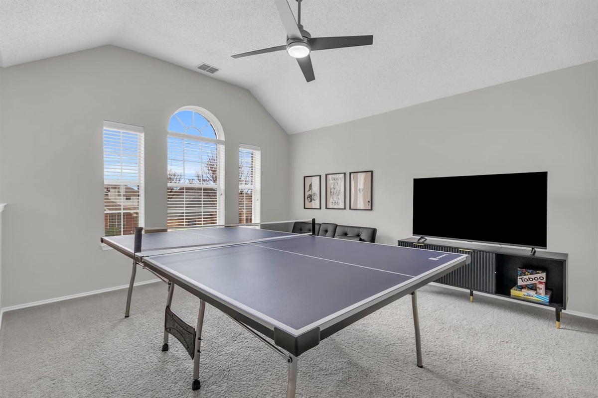 Indoor game room featuring a ping pong table, offering fun, weather-proof entertainment for families and group stays.