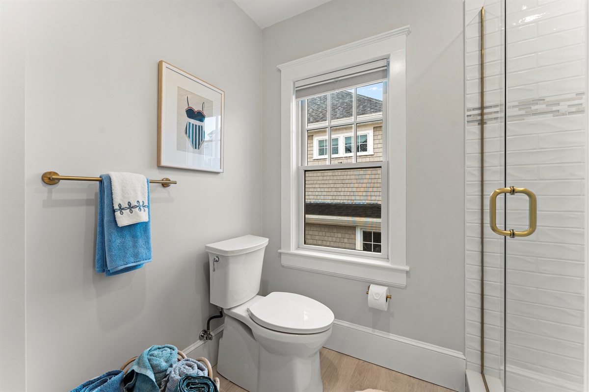Modern full bathroom featuring a walk-in shower and toilet.