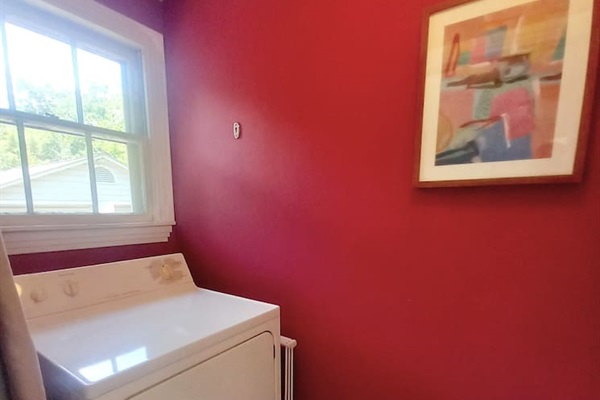 Separate laundry space includes full sized washer and dryer, ironing board, drying rack, drying line.