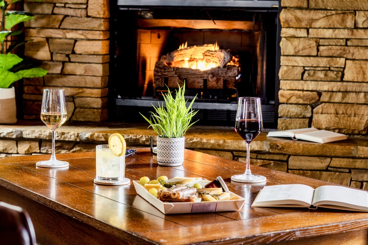 A romantic table setting, wine glasses, a book, and a flickering candle. KickBackStays.com Sevierville Cabins is the right place for romantic holidays. 