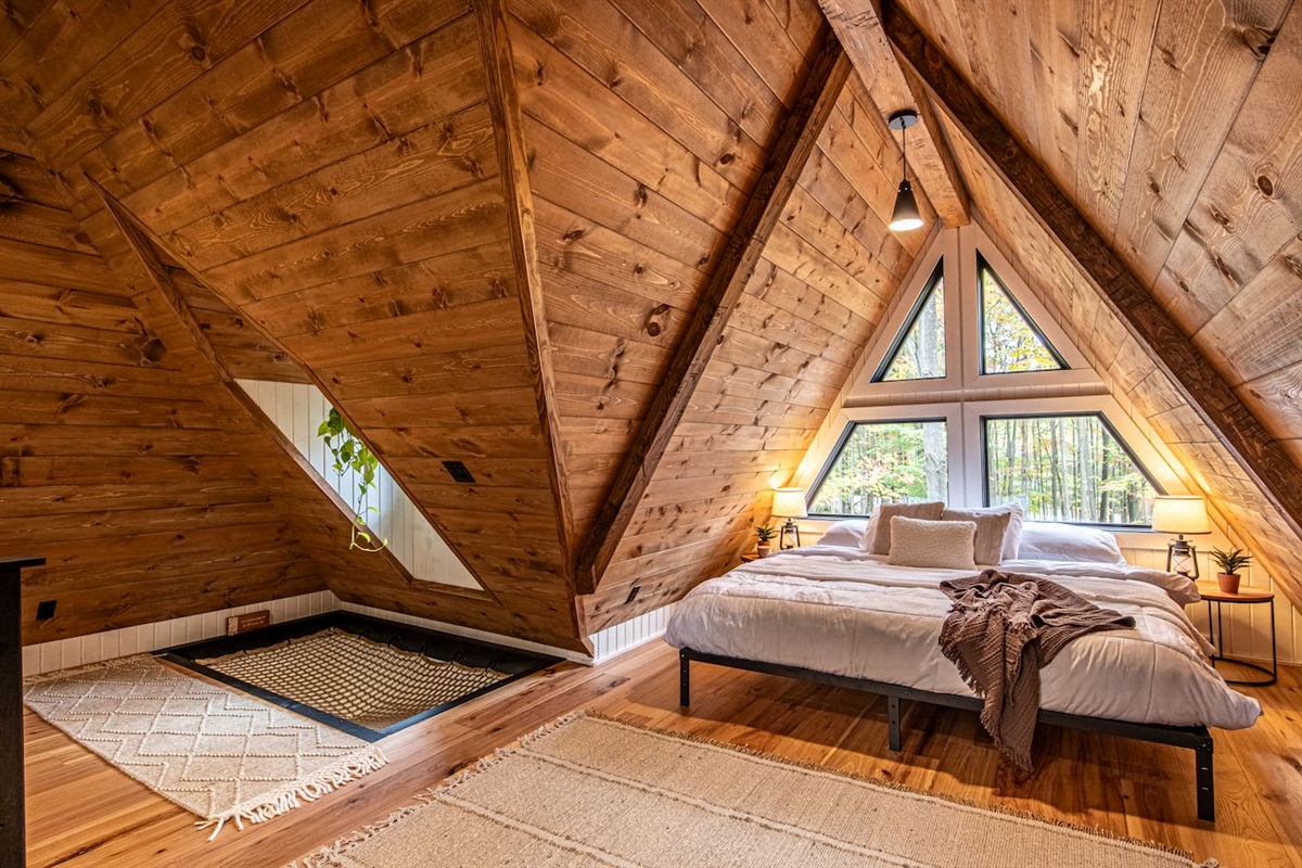 Adding a playful touch, a hammock is ingeniously built into the floor, perfect for lounging and soaking in the serene atmosphere. Nearby, a macrame swing hangs, providing a cozy nook to relax and sway gently while enjoying the tranquil forest view.