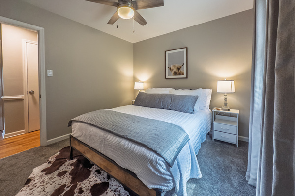 Queen bed, 55" Smart TV, ceiling fan, two led-light nightstands with multiple charging ports, two multi-light function lamps, blackout curtains, and full closet.