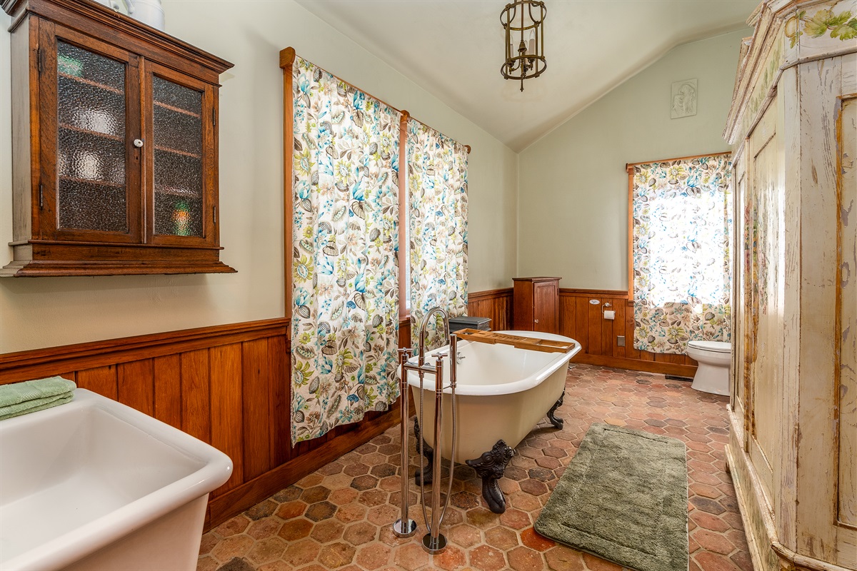Elegant bathroom featuring a classic clawfoot tub and unique Italian Cesame sink.
