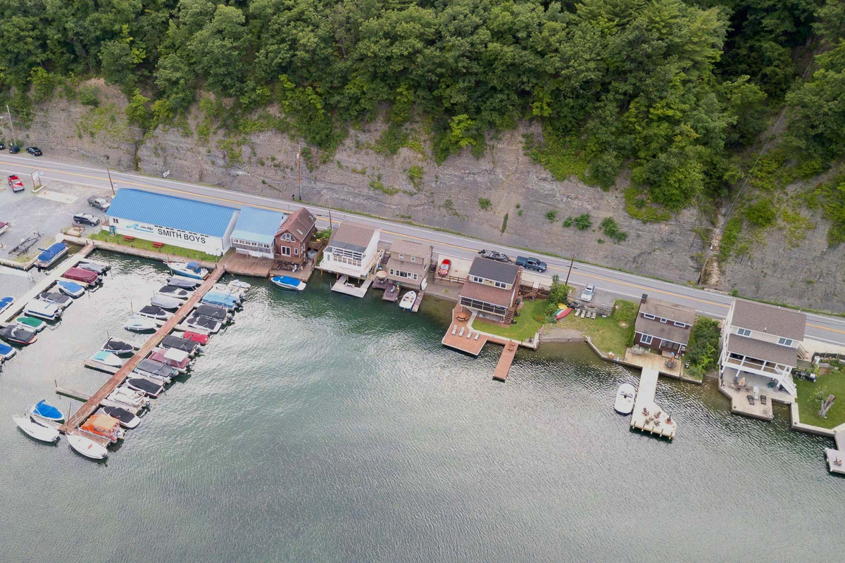 Nestled at the edge of a serene lake, this charming dock features a row of inviting, comfortable chairs, perfect for relaxing and enjoying the peaceful surroundings. The chairs, crafted from weather-resistant materials, are designed for comfort with 