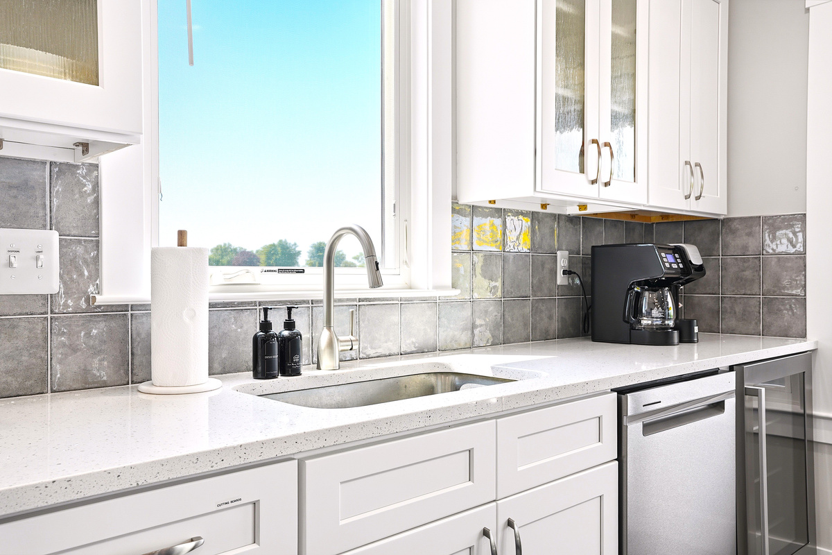 The clean, modern kitchen features a spacious sink, dishwasher, coffee maker, and plenty of counter space for everyday convenience.