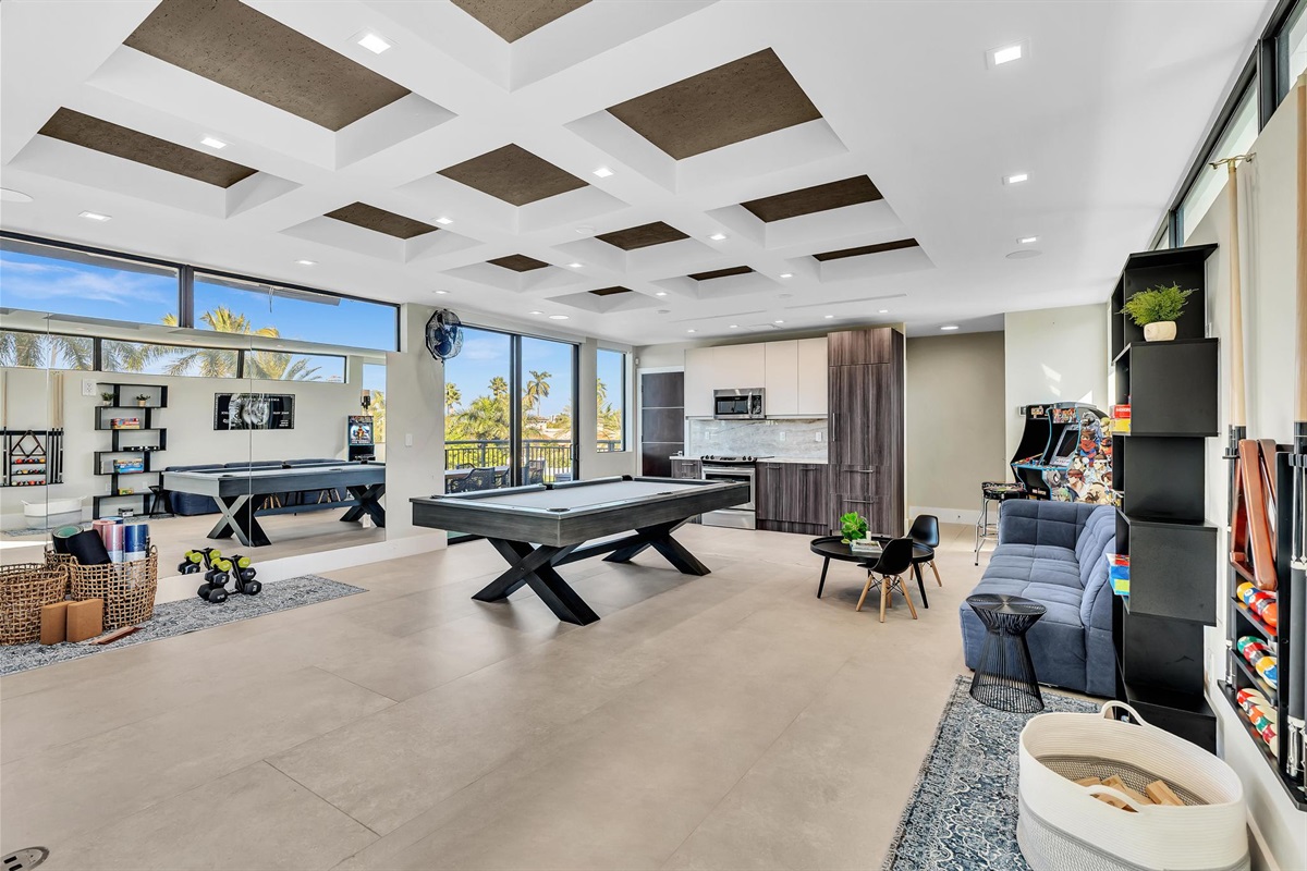 Spacious Club Room with pool table, arcade games, and lounge seating — the perfect indoor entertainment space for families and groups.