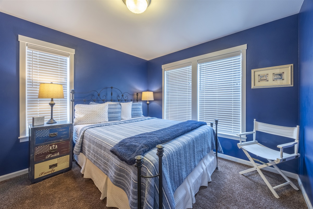 Relax in the queen room, featuring navy blue walls that capture the charm of coastal living.