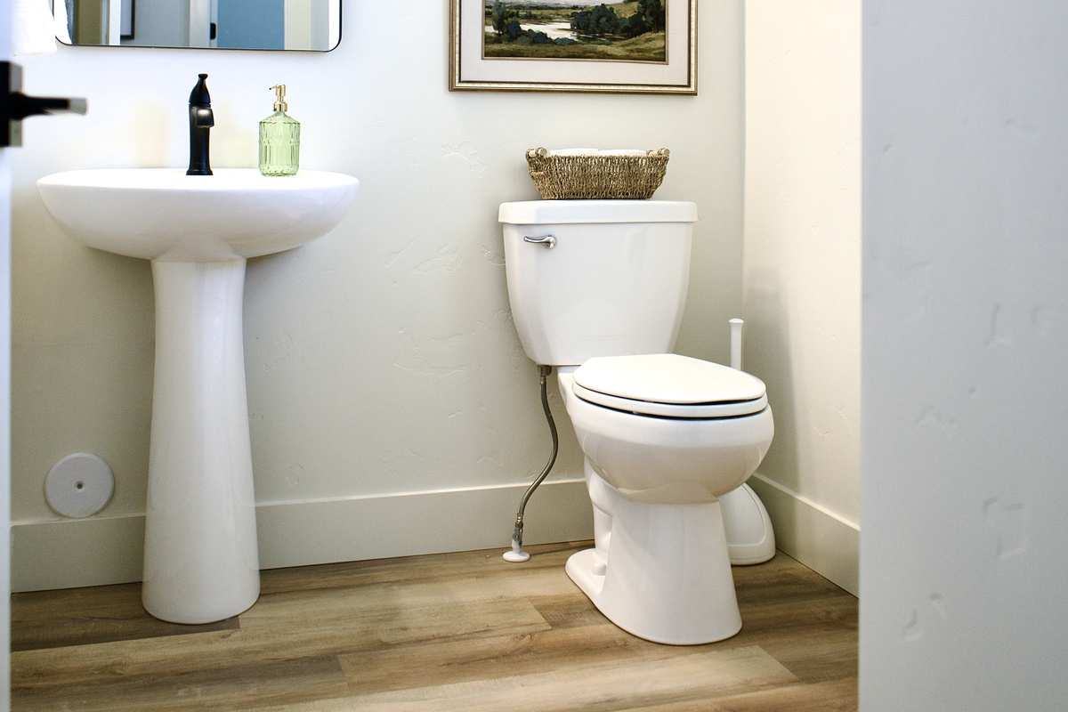 The spacious downstairs half bathroom features modern finishes and a thoughtfully designed layout, providing added convenience and comfort for guests.